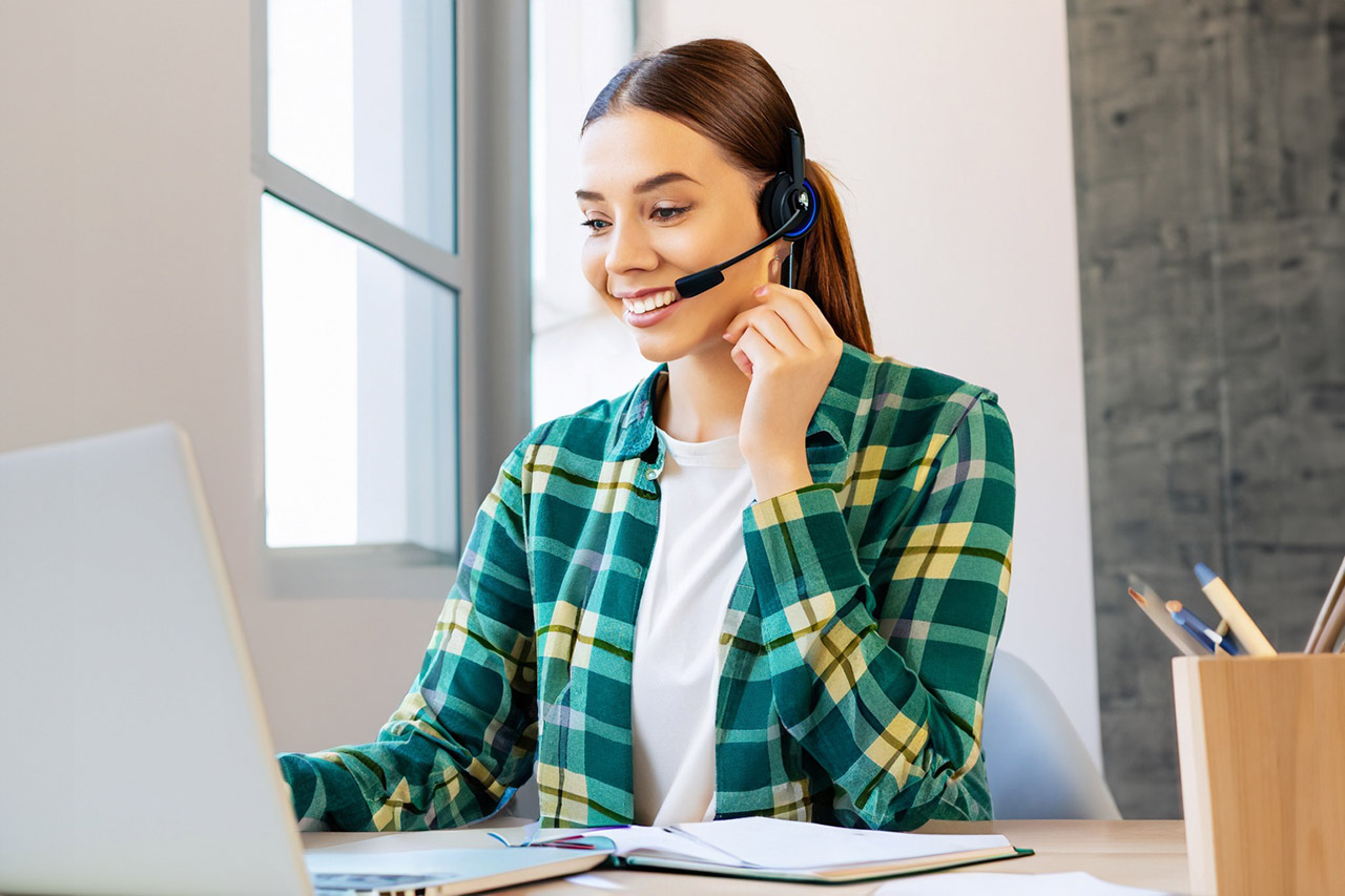 Telefonakquise: Junge Frau mit Headset während einer Neukunden-Kampagne